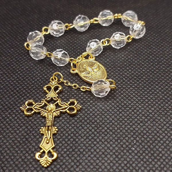 Beautiful Gold Catholic Baptism Rosary. 1 decade. 11 crystal cut round shaped acrylic beads. Gold links and chains. Ornate detailed Loretta crucifix. Our Holy Family center piece on back and with the Holy Spirit Dove on the front in gold. Handmade by Kim Williams Rosaries, The Village artist.