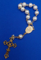 Beautiful Gold Catholic Baptism Rosary. 1 decade. 11 vintage ivory smooth round glass faux pearl beads. Gold links and chains. Ornate detailed Loretta crucifix. Our Holy Family center piece on back and with the Holy Spirit Dove on the front in gold.  Kim Williams Rosaries. The Village Artist.